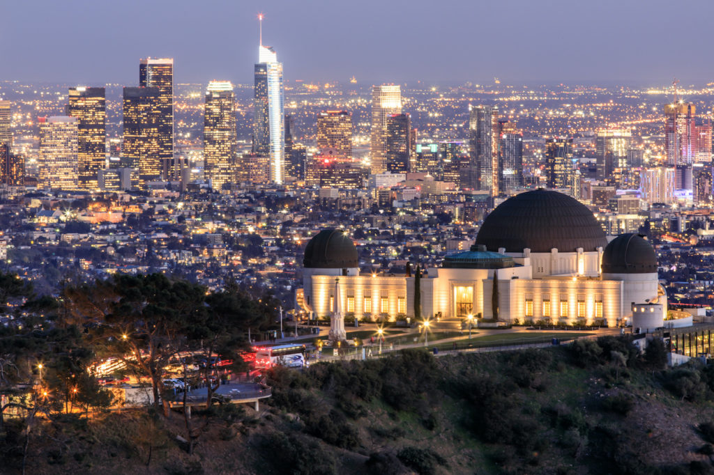 Griffith Observatory Park with Los Angeles Skyline at Dusk. Twilight views of the famous monument and downtown from Santa Monica Eastern Mountains.